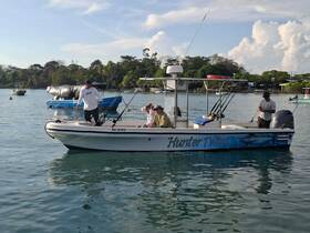 A group of fishermen aboard the 'Hunter Twins' boat, enjoying a day on the water, showcasing the excitement of fishing adventures.