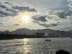 A serene sunset view featuring two kayakers on the water, with majestic mountains in the background — a perfect setting for outdoor adventures.