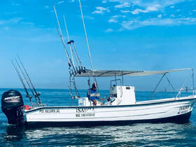 A fishing boat named 'ISAURA' is anchored in calm waters, showcasing its fishing gear and inviting atmosphere for a day of angling adventures.