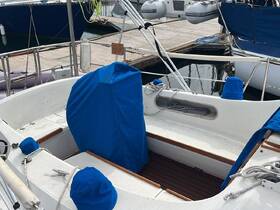 Interior view of a boat's cabin featuring blue covers on the seating, showcasing a clean and organized space ideal for relaxation on the water.