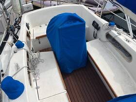 Interior view of a boat's helm area, featuring a covered console and neatly arranged ropes, ideal for showcasing the vessel's functional design.