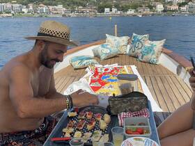 A man prepares delicious snacks on a boat, showcasing a perfect setup for dining and relaxation on the water.
