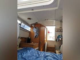 Interior view of a cozy boat cabin featuring a bed and storage areas, perfect for relaxing during a boating trip.