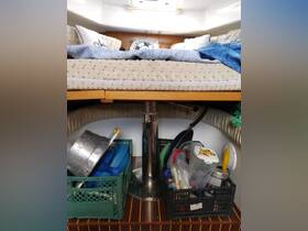 Interior view of a boat cabin featuring a cozy sleeping area and organized storage, showcasing the practical design and comfort of onboard living.