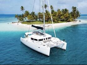 A stunning aerial view of a catamaran anchored near a tropical island, showcasing the vibrant turquoise waters and lush palm trees — perfect for a serene getaway.