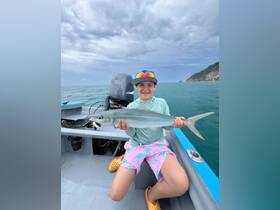 A young angler proudly displays their catch while fishing in the ocean, showcasing the thrill of fishing adventures for kids.