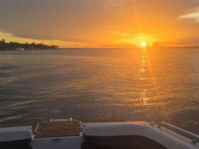 A stunning sunset view from the deck of a boat, showcasing the tranquil waters and vibrant colors of the evening sky — perfect for romantic cruises or peaceful getaways.