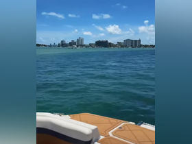 A scenic view of a vibrant coastline with city buildings in the background, showcasing the beauty of a day on the water.