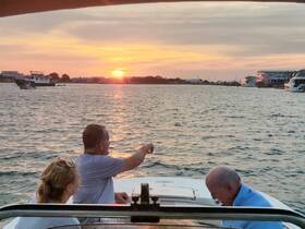 A group enjoys a picturesque sunset while boating, creating a perfect backdrop for memorable moments on the water.