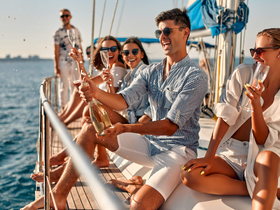 A lively group of friends celebrates aboard a sailboat, popping champagne and enjoying the sun — the perfect backdrop for unforgettable moments on the water.