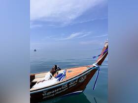 A woman relaxes on a beautifully decorated boat in tranquil waters, showcasing the perfect tropical getaway experience.