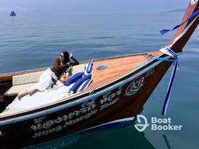 A woman relaxes on a beautifully crafted boat, surrounded by serene waters and tropical scenery — a perfect moment for leisure and exploration.
