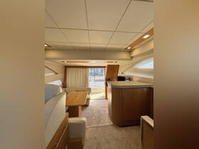A spacious and elegantly designed interior of a boat featuring a cozy seating area and dining table, perfect for relaxing and entertaining while on the water.
