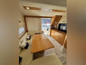 A cozy interior view of a yacht's cabin featuring a comfortable seating area and dining table, perfect for relaxing and enjoying meals while on the water.