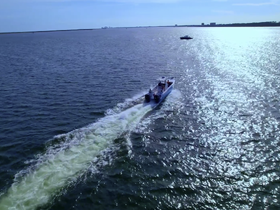 Aerial view of a speedboat cruising through shimmering waters, showcasing the thrill of boating adventures.