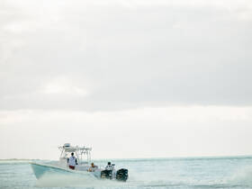 A boat speeds through the water with passengers onboard, showcasing the excitement of a day on the water.