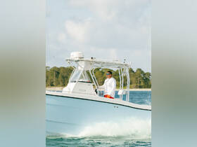 A captain navigates a boat through clear waters, showcasing the thrill of boating adventures on the open sea.