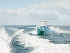 A sleek speedboat cuts through the water, showcasing its dynamic design and performance while underway. Perfect for thrill-seekers and water enthusiasts.