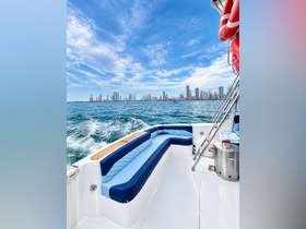 A beautifully designed seating area inside a boat, showcasing a comfortable cabin space with a stunning view of the skyline in the background.