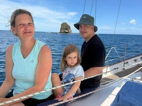 A family enjoys a sailing trip on the ocean, capturing a moment of joy and togetherness against a beautiful seascape.