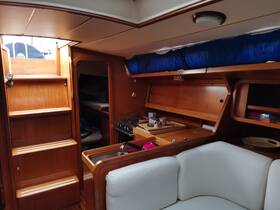Interior view of a cozy boat cabin featuring a seating area, kitchen space, and stairs leading to the deck — perfect for relaxing and enjoying time on the water.