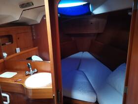 Interior view of a cozy boat cabin featuring a comfortable sleeping area and a small sink, perfect for relaxing on overnight trips.