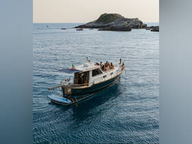 A lively group enjoys a day on the water aboard a boat, surrounded by stunning coastal scenery — perfect for summer adventures and relaxation.