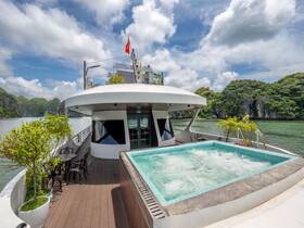 A luxurious jacuzzi on the deck of a boat, surrounded by scenic views of lush greenery and calm waters, perfect for relaxation during a cruise.