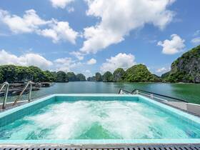 A luxurious jacuzzi on a boat offers stunning views of lush green islands and tranquil waters, perfect for relaxation while enjoying the beautiful scenery.