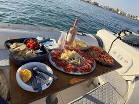 A beautifully arranged spread of charcuterie, snacks, and drinks on a boat, perfect for enjoying a relaxing day on the water.