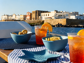 A delightful spread of snacks and cocktails on a boat, perfect for enjoying the scenic views while cruising. Ideal for a relaxing day on the water.