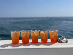 A refreshing display of cocktails on a boat, perfect for enjoying a sunny day on the water. Ideal for gatherings and celebrations.