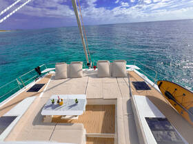 A beautifully designed lounge area on a yacht, featuring comfortable seating and a table, perfect for relaxing while enjoying stunning ocean views.