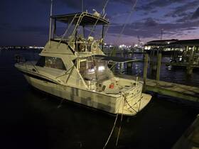A serene view of a yacht docked at night, illuminated by soft lights, showcasing its elegant design against a twilight backdrop.