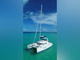 A stunning aerial view of a catamaran sailing through crystal-clear turquoise waters, showcasing its sleek design and vibrant surroundings — perfect for island adventures.