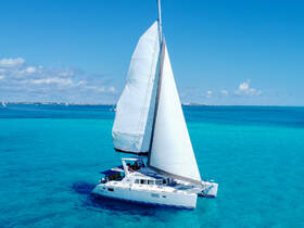 A stunning aerial view of a catamaran sailing through crystal-clear turquoise waters, perfect for exploring beautiful destinations.