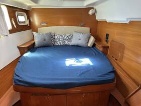 Cozy cabin interior featuring a comfortable double bed adorned with decorative pillows, perfect for relaxing during a boating trip.