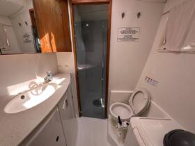 Interior view of a boat's bathroom, featuring a sink, toilet, and shower area, designed for comfort and convenience while on the water.