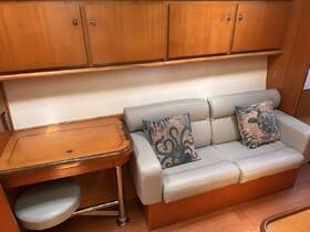 Cozy interior of a boat featuring a comfortable seating area and a wooden table, perfect for relaxing or dining while on the water.