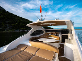 A beautifully designed interior of a boat featuring comfortable seating and a well-equipped helm, perfect for relaxing and navigating on the water.
