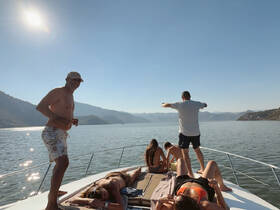 A lively group enjoys a sunny day on the boat, with friends sunbathing and having fun on the water — perfect for summer outings and relaxation.