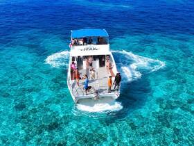 A vibrant scene aboard the Ocean Titan with guests enjoying the clear turquoise waters, perfect for snorkeling adventures and family outings.