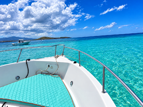 A stunning view from the bow of a boat, showcasing the vibrant turquoise waters and a distant vessel, perfect for a day of exploration and relaxation on the water.