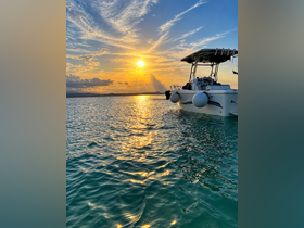 A stunning sunset view featuring a boat anchored in tranquil waters, reflecting golden hues — perfect for serene evening cruises.