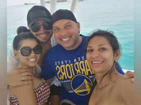 A cheerful group of friends poses for a selfie on a boat, enjoying a sunny day on the ocean — perfect for memorable outings and adventures.