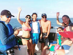 A lively group enjoys a fun moment on a boat, waving and celebrating together — perfect for creating unforgettable memories on the water.