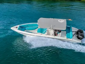 A sleek speedboat glides through clear turquoise waters, showcasing its stylish design and comfortable seating — perfect for thrilling water adventures.