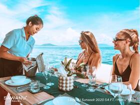 Guests enjoy a luxurious dining experience aboard the Lady MJ Sunseek yacht, with stunning ocean views and elegant table settings, perfect for special celebrations.