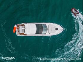 Aerial view of the Lady M Sunseek 2020 motor yacht cruising through vibrant turquoise waters, showcasing its sleek design and spacious deck.