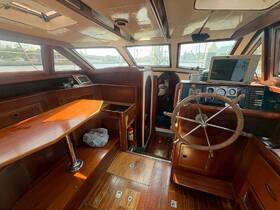 Interior view of a boat's helm and cabin area, showcasing the wooden finishes and navigation equipment, perfect for a comfortable sailing experience.